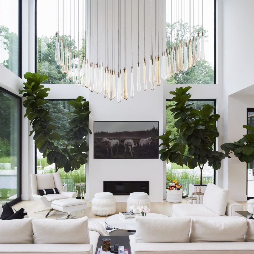 Dew pendant lights hung as a chandelier in a large white living room with tall ceilings